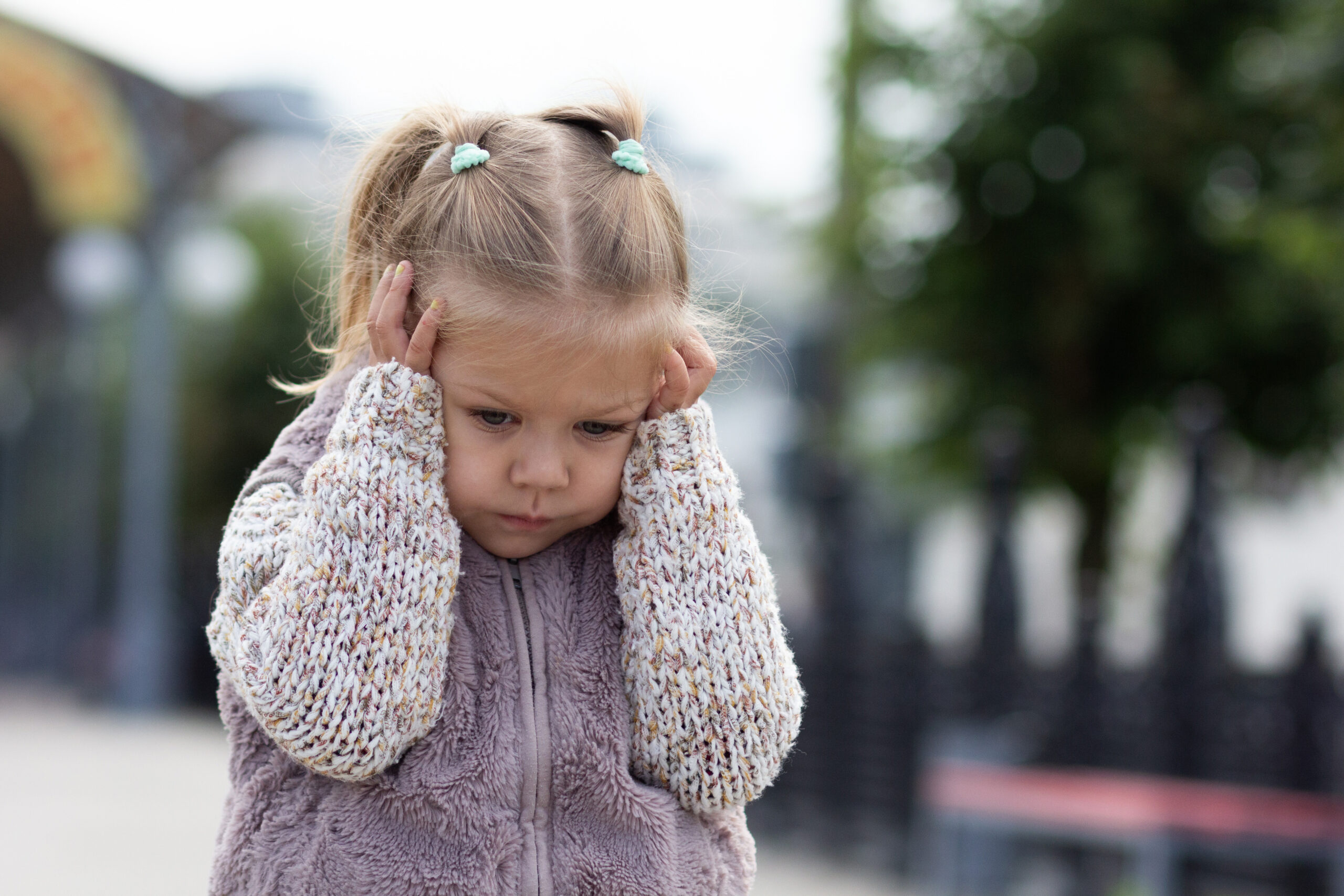 Worried child with hands on head.